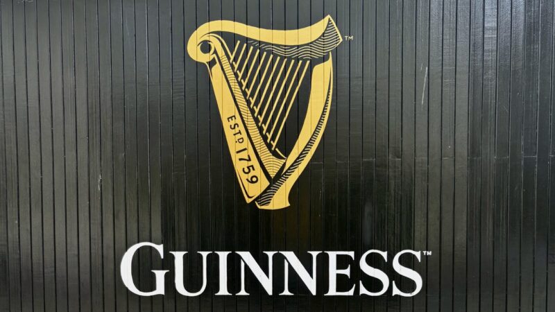 black wall with Guinness written on it and a gold harp